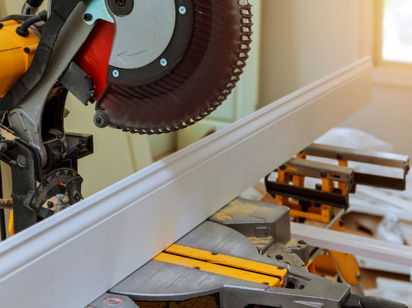 Circular saw positioned above moulding, ready to cut.